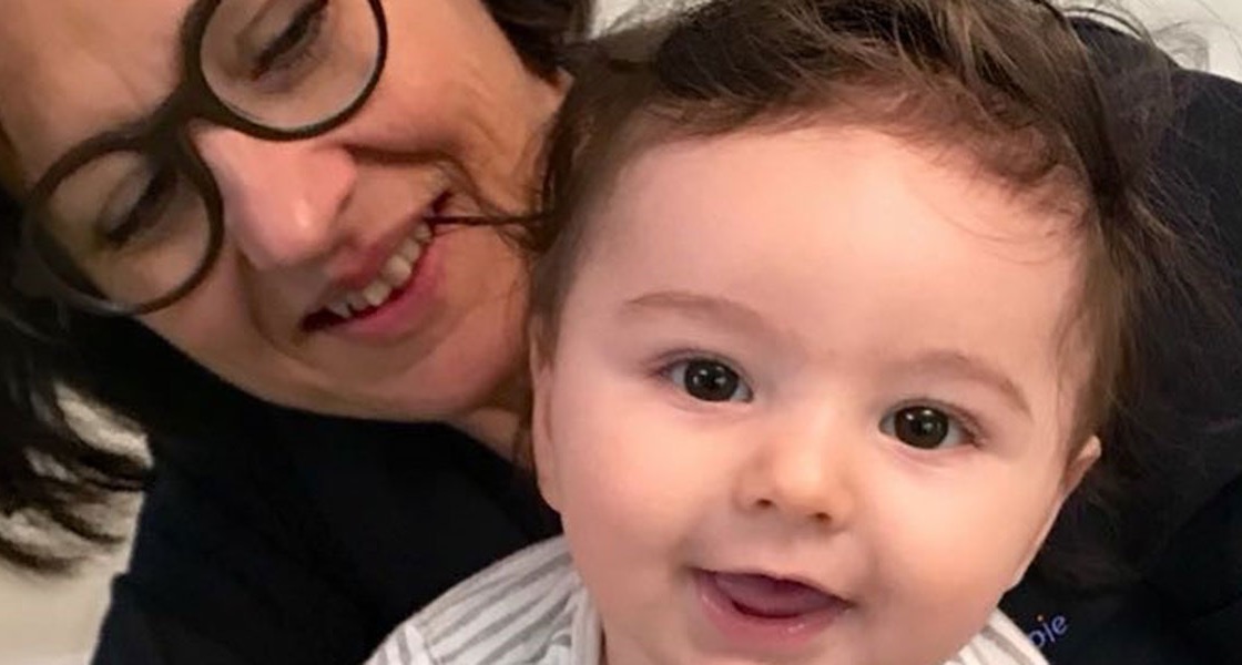 Ulrike Angler lacht mit einem Baby während einer kinderosteopathischen Behandlung